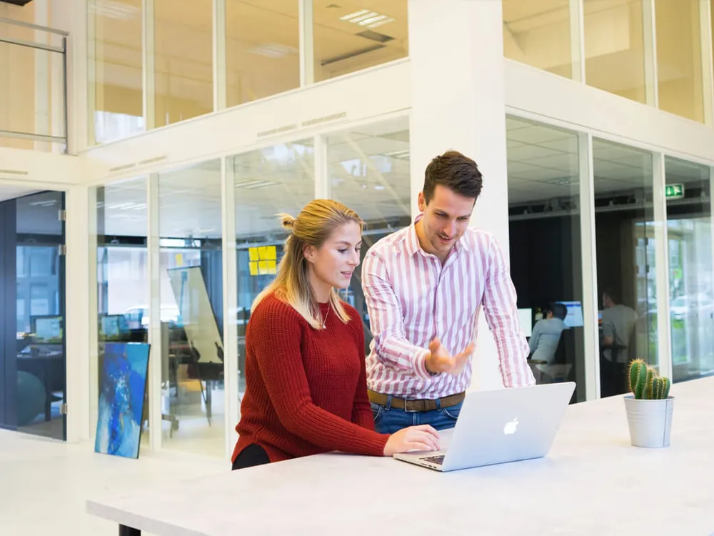 Two people reviewing information together on a laptop