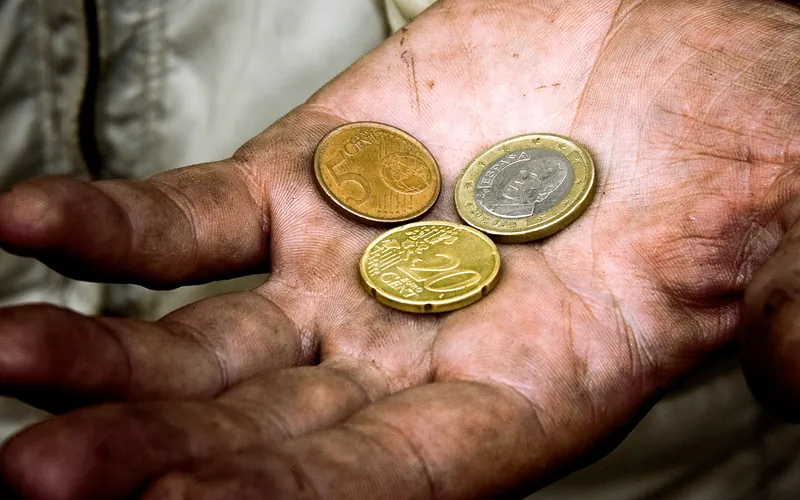 Elderly hands holding coins